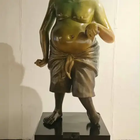 Patung perunggu sosok pria sepuh berkain sarung